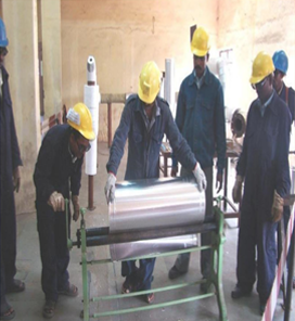 Workers working with a large metal cylinder